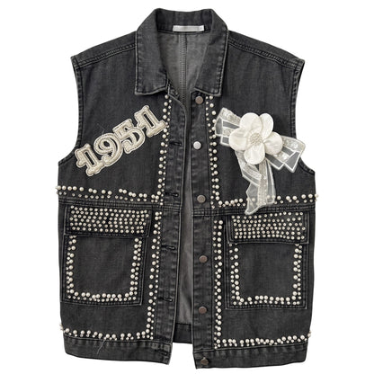 Creatively Chaotic Luxury Boutique washed black denim vest with crystal 1951 appliqué, faux pearls, and floral bow.